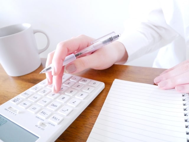 電卓で計算する女性